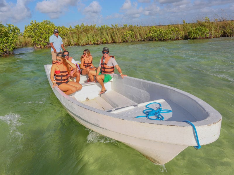five people in a boat visiting cancun in the summer months