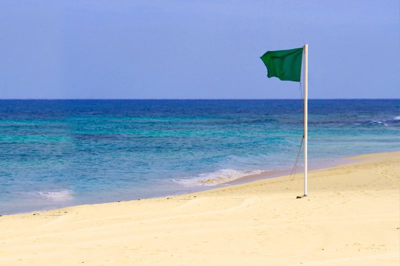 Green flag indicating a swimmable beach in Cabo