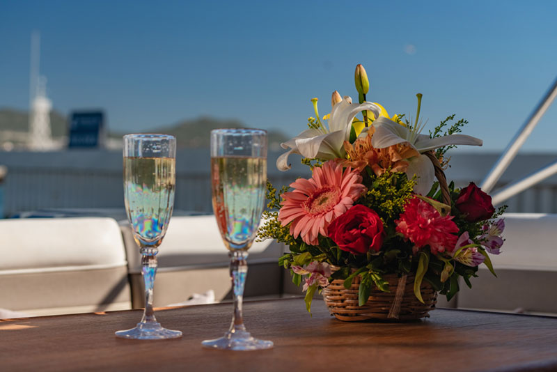 Champagne glasses and flowers for honeymooning couple on Cabo Adventures’ private yacht