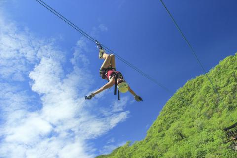 woman upside down on zip line in cabo mexico