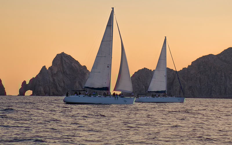 luxury sail boats at sunset in cabo|