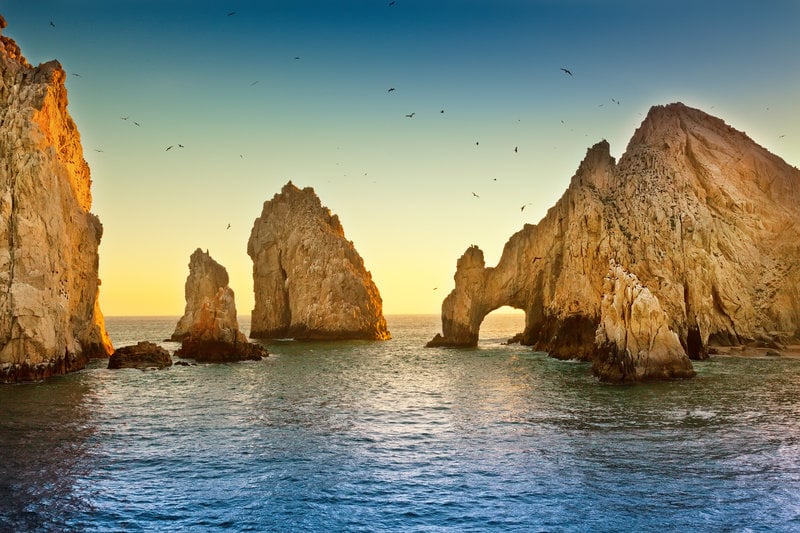 The sun setting behind the Arch of Cabo San Lucas