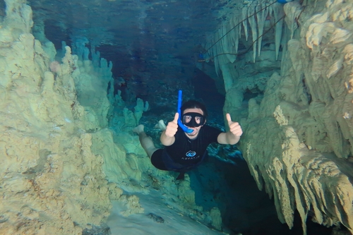 man scuba snorkeling in underground cave