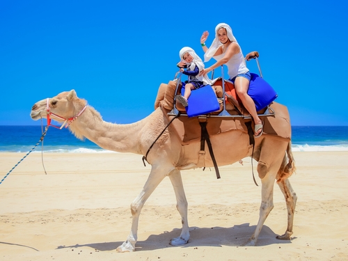 woman and young boy camel back riding