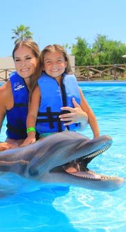 Mom and daughter with a dolphin in cabo