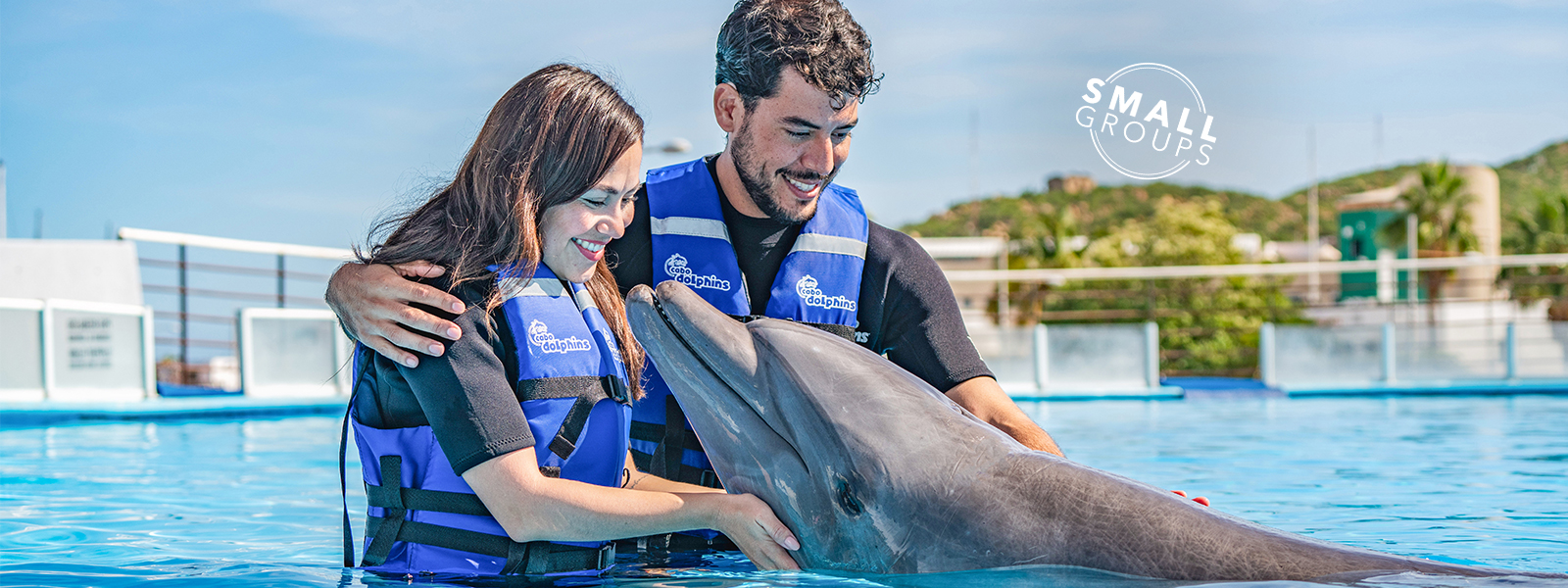 Couple hugging a dolphin in Cabo Adventures