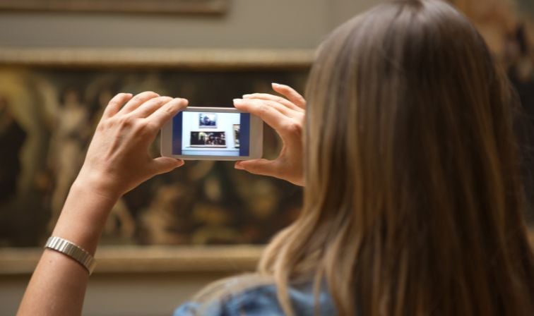 Woman taking photos of a display in a museum