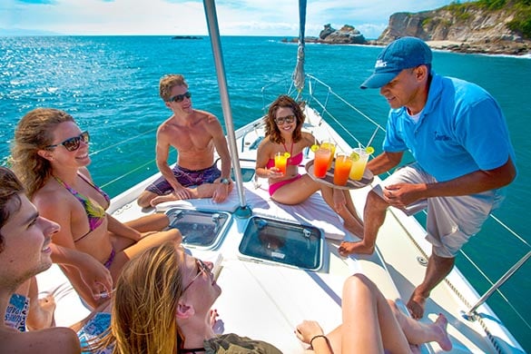 Tourists being served drinks on board a sailboat during our Luxury Sailing excursion in Puerto Vallarta