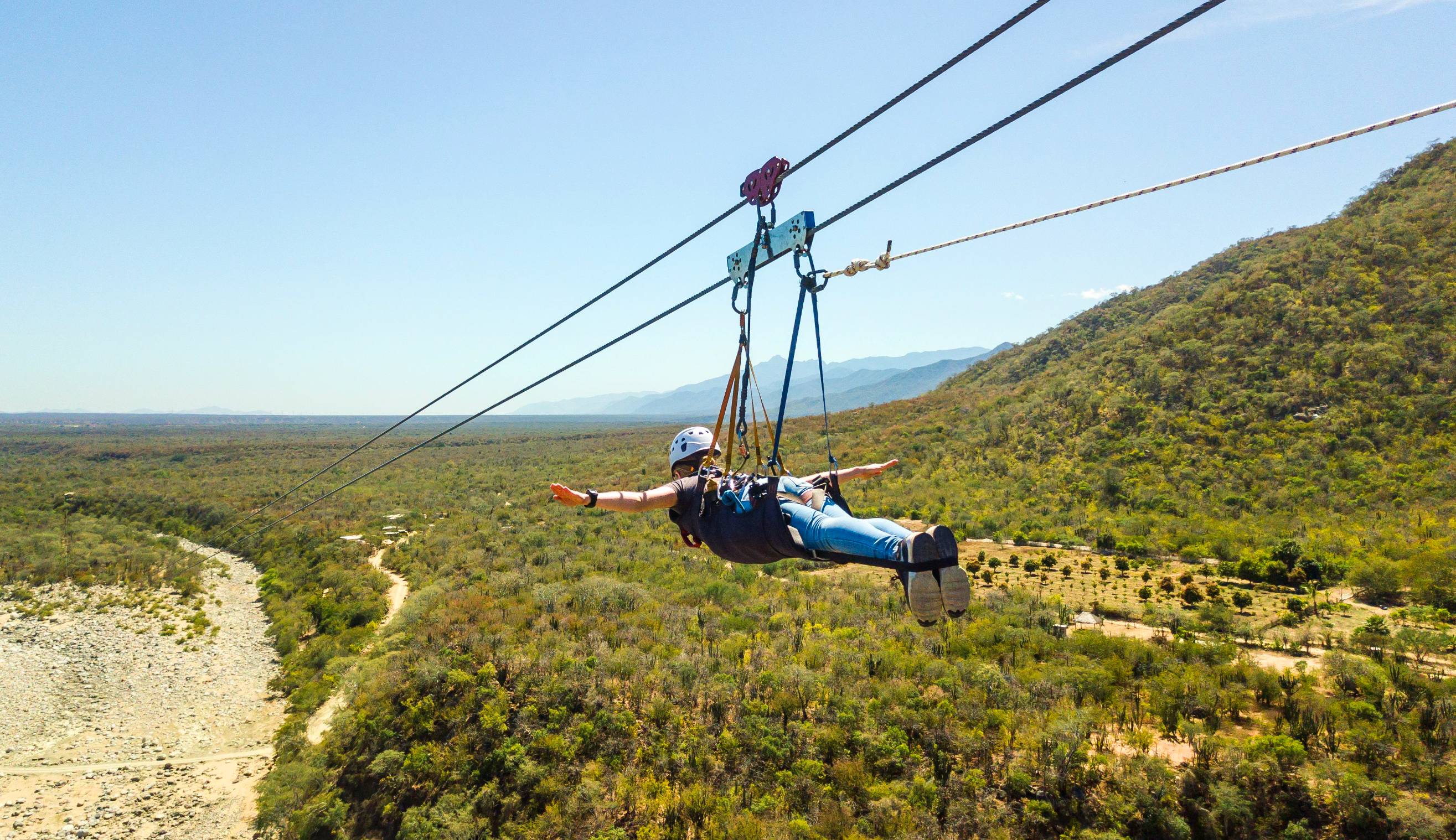 Young woman flying in Cabo's longest zipline by Cabo Adventures