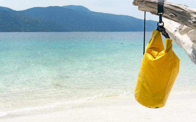yellow water proof day bag hanging from tree