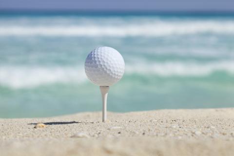 teed up golf ball on a cancun beach