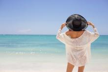 woman standing on a beach wearing perfect beach outfit for cancun vacation