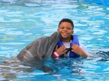 Boy swimming with dolphin